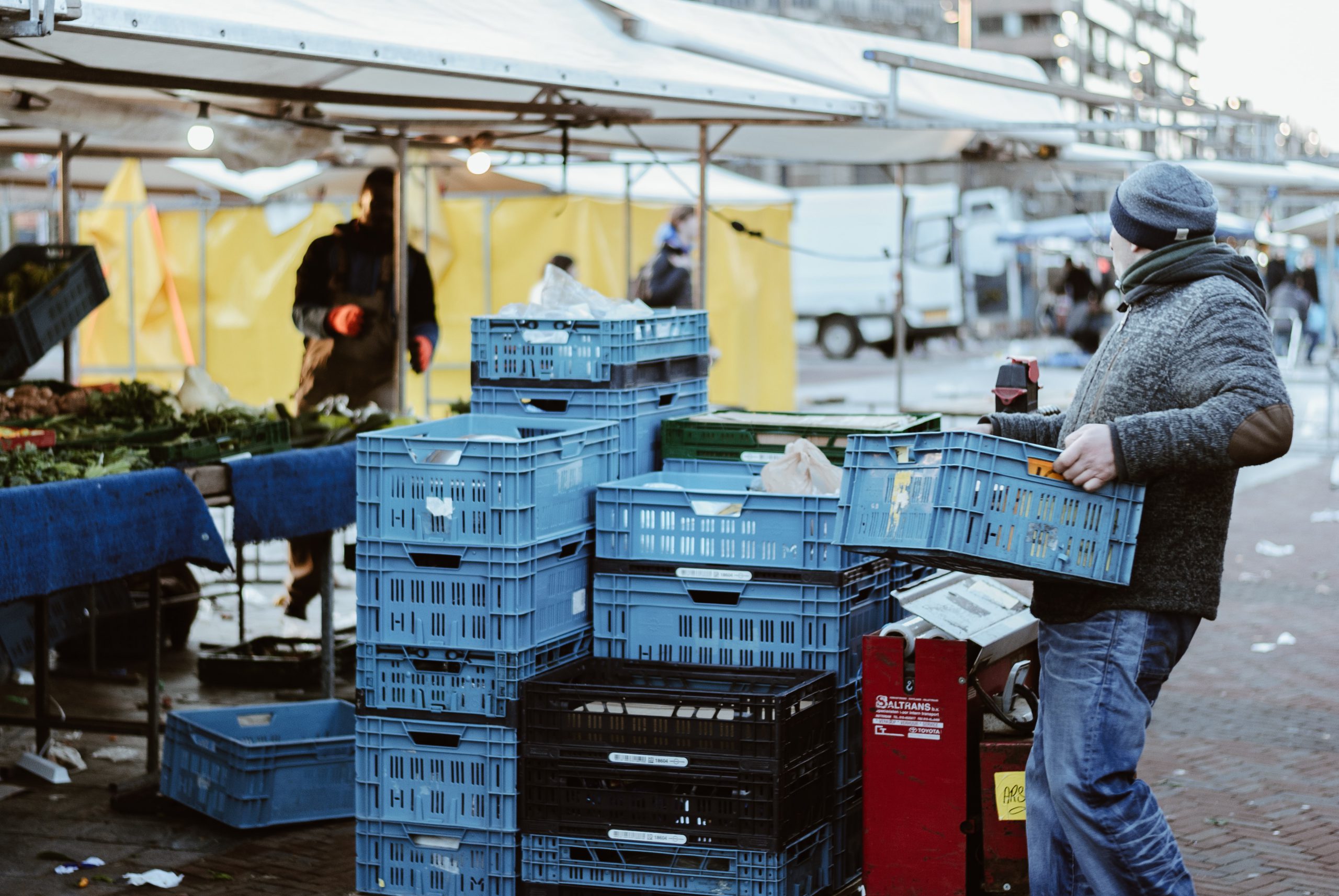 foto man die krat tilt op de markt bij artikel over aansprakelijkheid voor schade veroorzaakt door werknemers