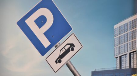 Een afbeelding van een verkeersbord van een parkeerplaats bij een juridische blog over een arrest van de Hoge Raad over de opstalaansprakelijkheid voor een parkeerplaats.